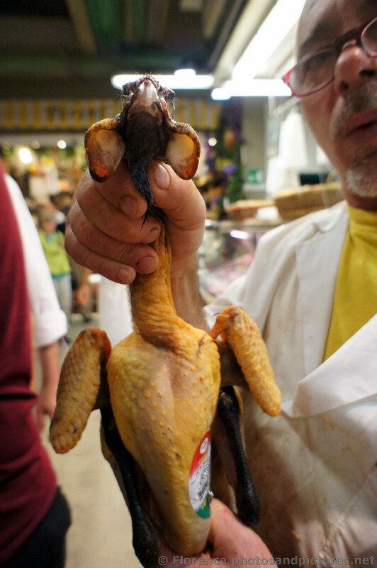 Butcher holds up a plucked small turkey at the Mercato Centrale.jpg