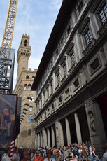 Tower of Palazza Vecchio loom into view on Piazzale degli Uffizi.jpg